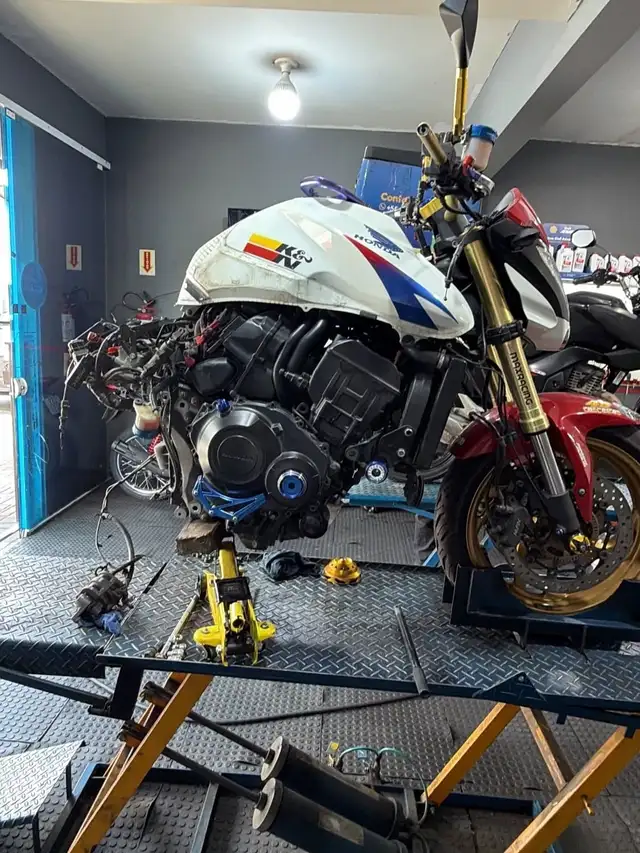 Honda CB1000R branca desmontada no elevador