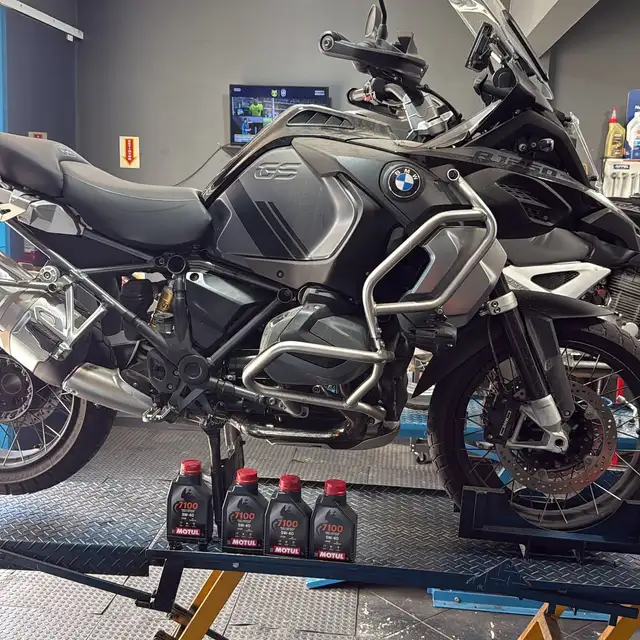 BMW R1250 preta no elevador com frascos de óleo ao lado