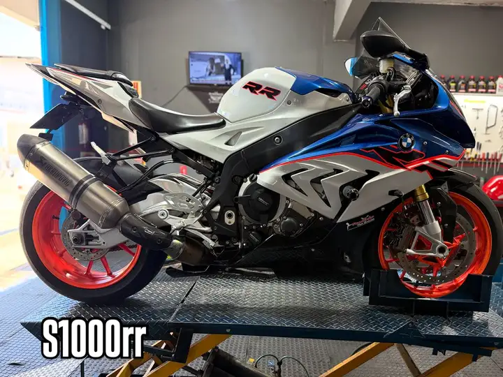 BMW S1000RR branca, azul e vermelha no elevador